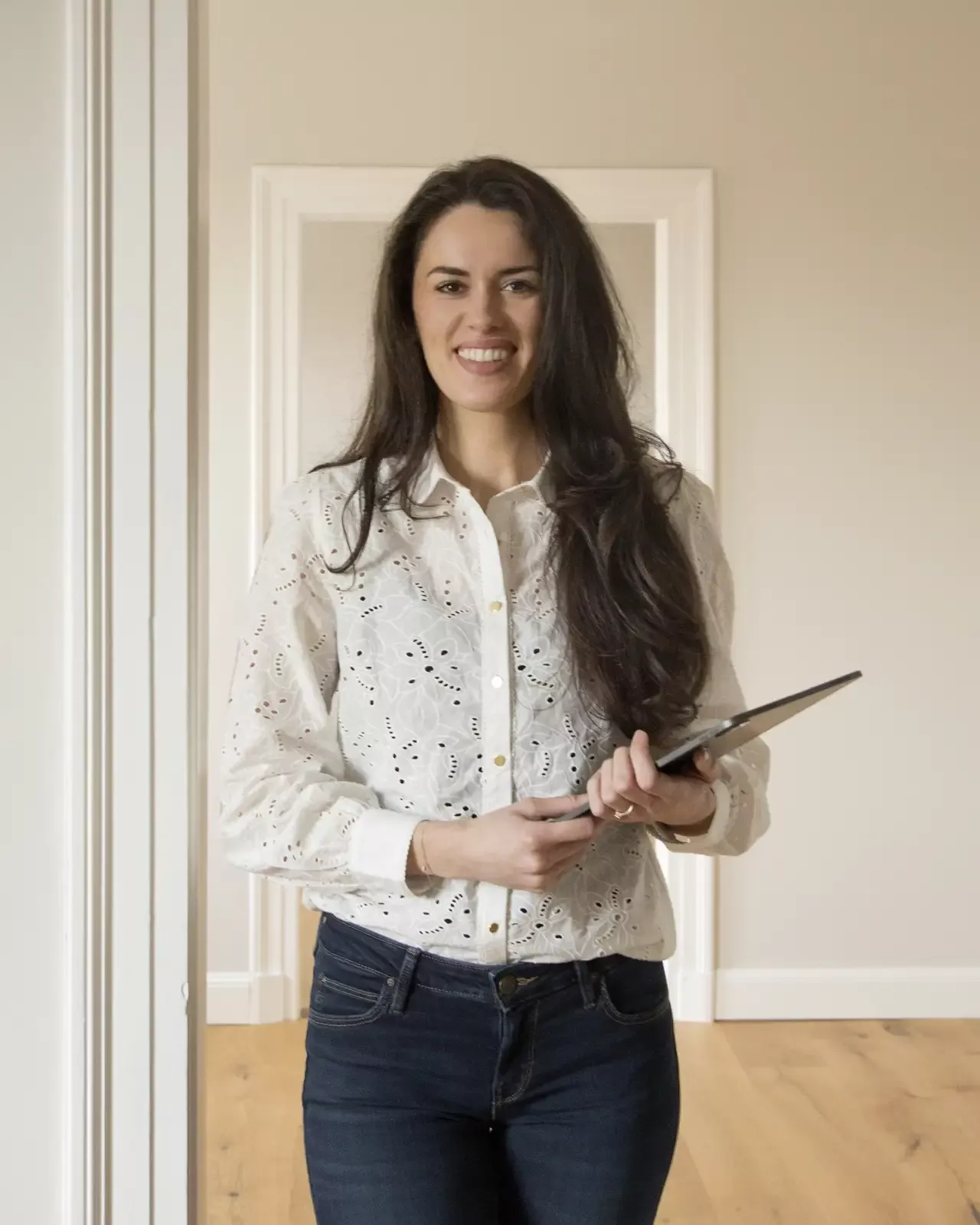 Die Immobilienmaklerin Nona Post steht mit dem Tablet in einer zu verkaufenden Immobilie.